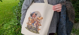 A natural cotton tote bag featuring a Renn Faire or fantasy inspired girl running through oversized mushrooms.  She wears a kerchief and a plaid skirt, and her hair is floating behind her.